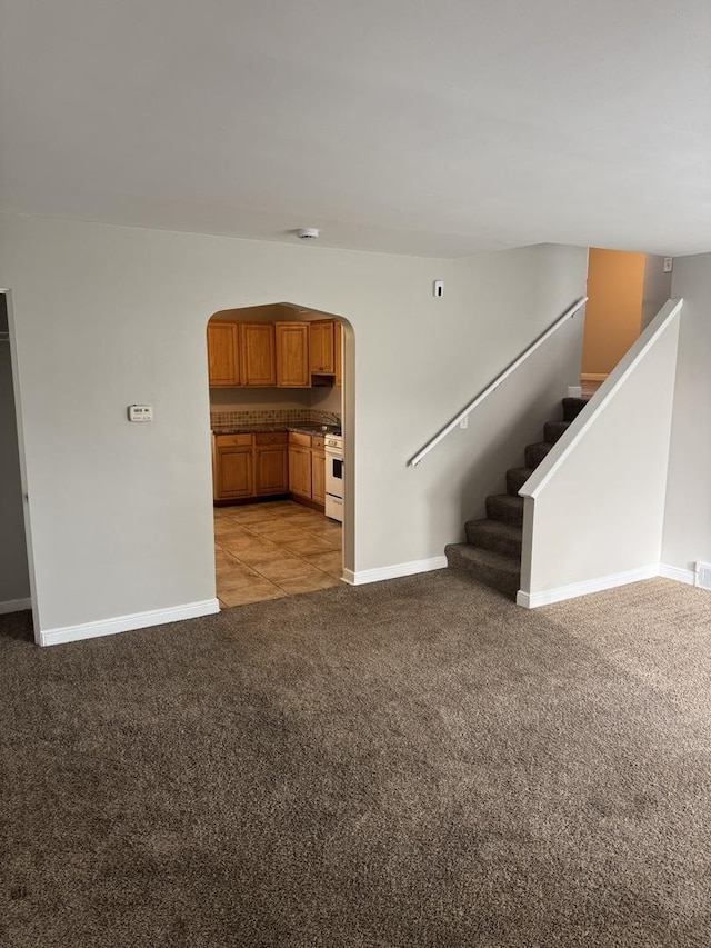 2219 S 13th Ave, Broadview, IL 60155 - unfurnished living room with arched walkways, light carpet, baseboards, and stairway