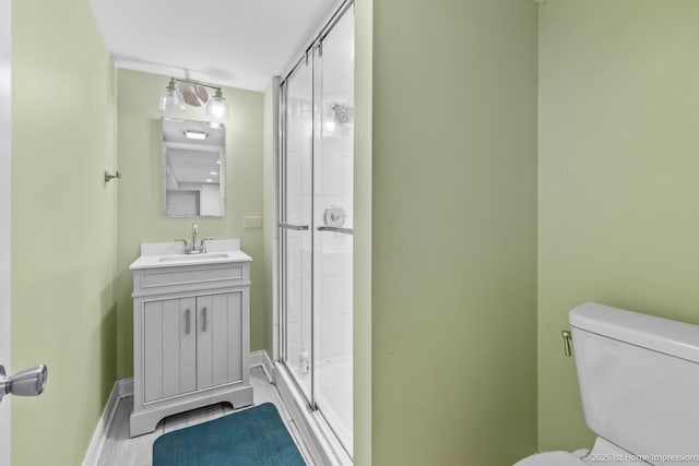 2312 S 1st Ave, North Riverside, IL 60546 - bathroom featuring a shower with door, baseboards, toilet, and vanity