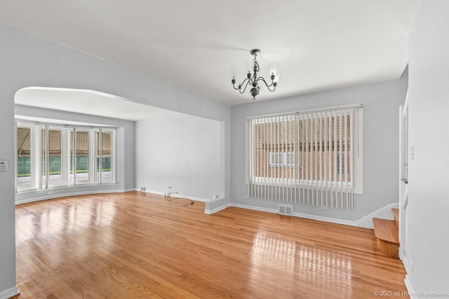 2312 S 1st Ave, North Riverside, IL 60546 - unfurnished living room featuring a chandelier, baseboards, wood finished floors, and stairs