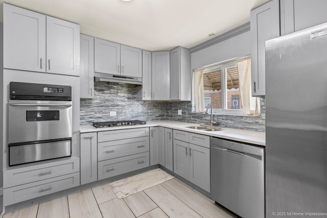 2312 S 1st Ave, North Riverside, IL 60546 - kitchen featuring appliances with stainless steel finishes, a warming drawer, gray cabinetry, a sink, and under cabinet range hood