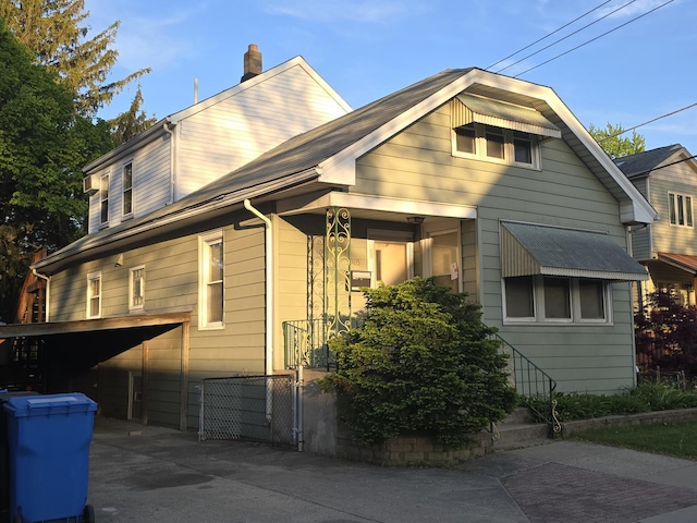 3905 N Oak Park Ave, Chicago, IL 60634 - view of side of home featuring a chimney, concrete driveway, and an attached garage