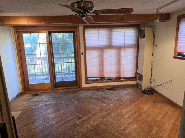 3905 N Oak Park Ave, Chicago, IL 60634 - unfurnished dining area with a heating unit, baseboards, a ceiling fan, wood finished floors, and a textured ceiling