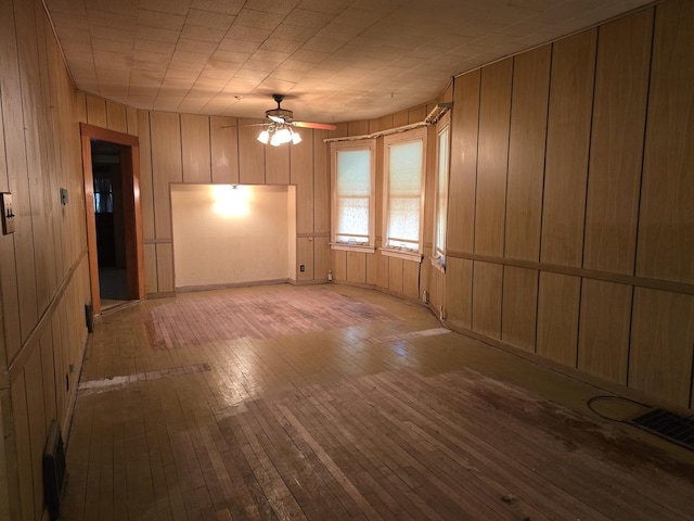 3905 N Oak Park Ave, Chicago, IL 60634 - unfurnished living room featuring wood-type flooring, ceiling fan, and wooden walls