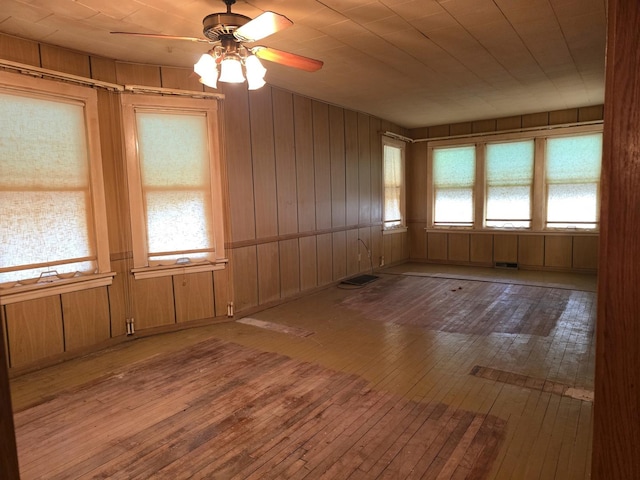 3905 N Oak Park Ave, Chicago, IL 60634 - unfurnished room featuring wood-type flooring, ceiling fan, and wooden walls