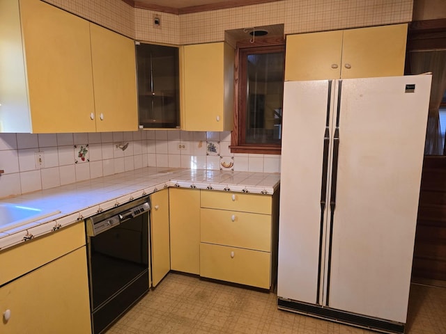 3905 N Oak Park Ave, Chicago, IL 60634 - kitchen with freestanding refrigerator, dishwasher, light flooring, cream cabinets, and decorative backsplash