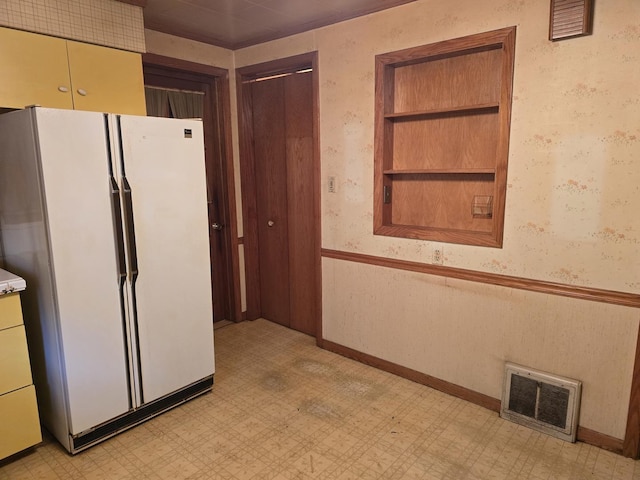 3905 N Oak Park Ave, Chicago, IL 60634 - kitchen featuring freestanding refrigerator, light flooring, wallpapered walls, and baseboards