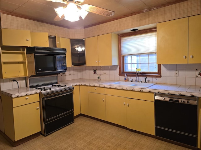3905 N Oak Park Ave, Chicago, IL 60634 - kitchen with black appliances, a sink, tasteful backsplash, ceiling fan, and light floors