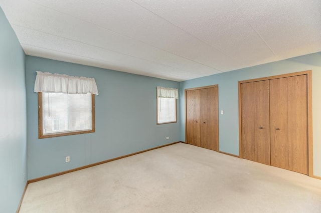 464 S President St Unit 101, Carol Stream, IL 60188 - unfurnished bedroom with carpet flooring, multiple closets, and baseboards