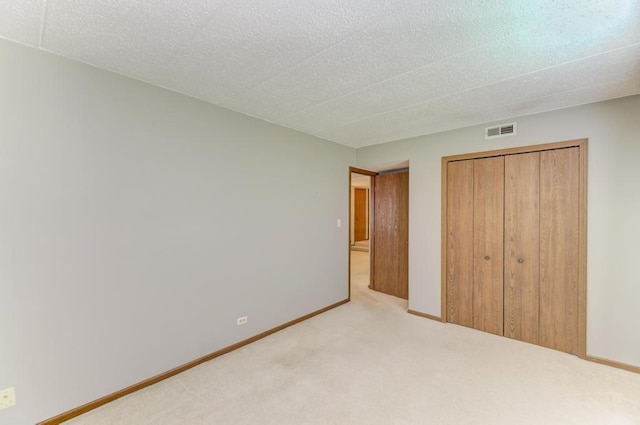 464 S President St Unit 101, Carol Stream, IL 60188 - unfurnished bedroom with carpet floors, a closet, baseboards, and a textured ceiling