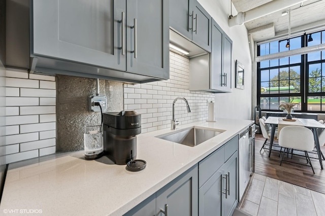 3963 W Belmont Ave Unit 140, Chicago, IL 60618 - kitchen featuring a sink, stainless steel dishwasher, light countertops, and gray cabinets