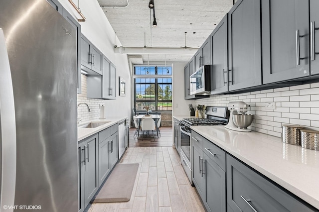 3963 W Belmont Ave Unit 140, Chicago, IL 60618 - kitchen with stainless steel appliances, a sink, and gray cabinetry