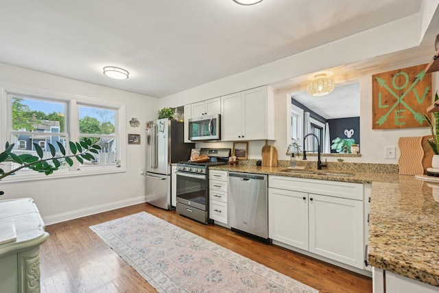 324 W Crystal Lake Ave, Crystal Lake, IL 60014 - kitchen with appliances with stainless steel finishes, a sink, wood finished floors, white cabinetry, and a chandelier