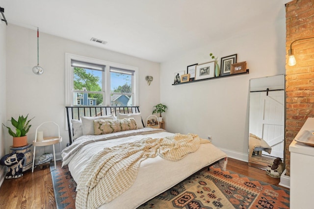 324 W Crystal Lake Ave, Crystal Lake, IL 60014 - bedroom featuring a barn door, wood finished floors, and baseboards