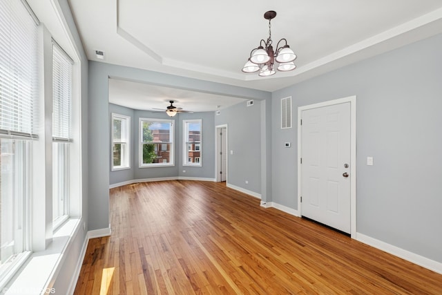 157 N Leamington Ave, Chicago, IL 60644 - unfurnished room with light wood-style flooring, a chandelier, a raised ceiling, and a ceiling fan