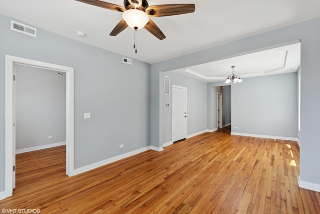 157 N Leamington Ave, Chicago, IL 60644 - spare room with light wood finished floors, a chandelier, a tray ceiling, and a ceiling fan
