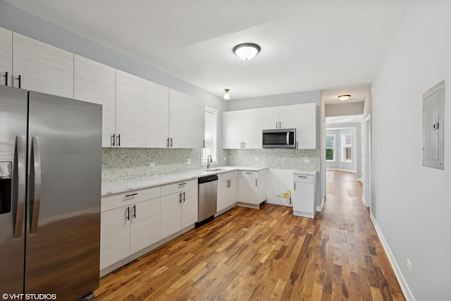 157 N Leamington Ave, Chicago, IL 60644 - kitchen with stainless steel appliances, electric panel, tasteful backsplash, wood finished floors, and light countertops