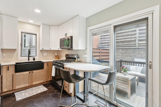 1248 W Fletcher St Unit C, Chicago, IL 60657 - kitchen featuring appliances with stainless steel finishes, a sink, light countertops, decorative backsplash, and recessed lighting