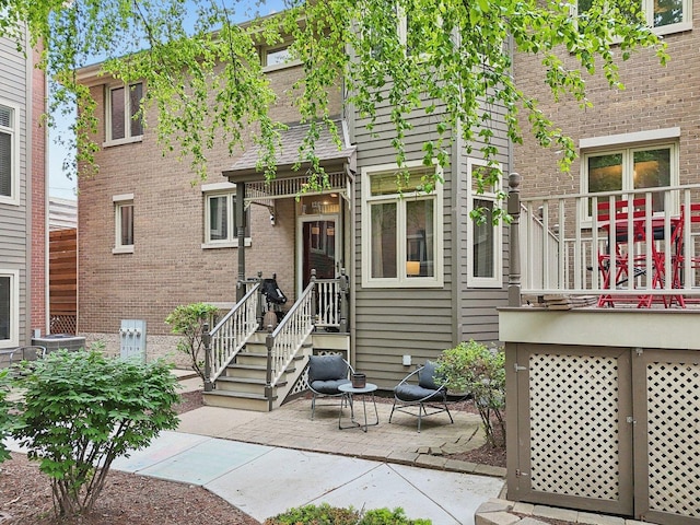 1248 W Fletcher St Unit C, Chicago, IL 60657 - view of front facade featuring brick siding and a patio