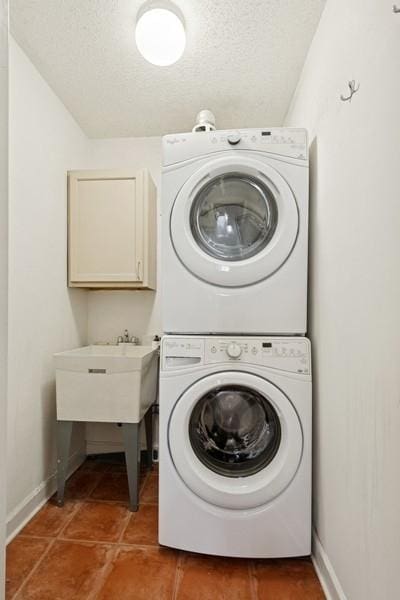 1430 N Astor St Unit 11C, Chicago, IL 60610 - washroom with stacked washer / dryer, baseboards, cabinet space, and a textured ceiling