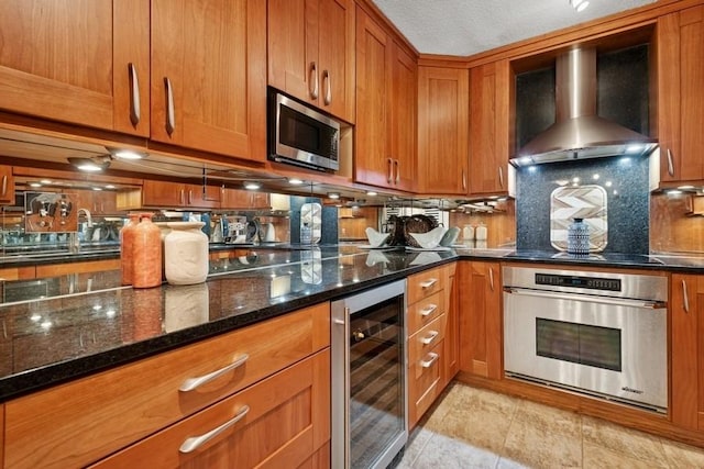 1430 N Astor St Unit 11C, Chicago, IL 60610 - kitchen featuring appliances with stainless steel finishes, wine cooler, wall chimney range hood, and brown cabinetry