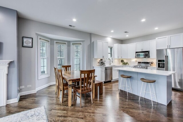 1952 W Fletcher St Unit 2W, Chicago, IL 60657 - kitchen featuring appliances with stainless steel finishes, dark wood finished floors, light countertops, white cabinetry, and recessed lighting