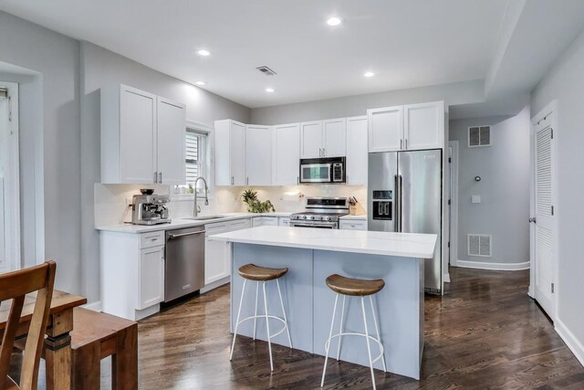 1952 W Fletcher St Unit 2W, Chicago, IL 60657 - kitchen featuring stainless steel appliances, a sink, a kitchen island, tasteful backsplash, and a breakfast bar area