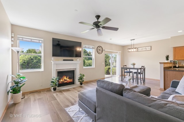 6417 Blue Sky Ln, Matteson, IL 60443 - living room featuring healthy amount of natural light, light wood-style floors, a glass covered fireplace, and ceiling fan