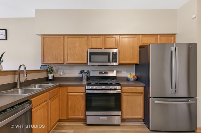 6417 Blue Sky Ln, Matteson, IL 60443 - kitchen featuring appliances with stainless steel finishes, a sink, dark countertops, and light wood-style floors