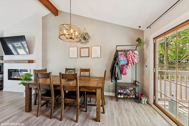 2109 Sprucewood Ln, Lindenhurst, IL 60046 - dining area with light wood-style floors, a chandelier, a large fireplace, and baseboards