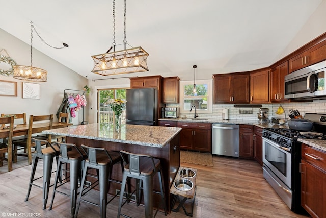 2109 Sprucewood Ln, Lindenhurst, IL 60046 - kitchen featuring stainless steel appliances, lofted ceiling, a sink, light wood-style flooring, and tasteful backsplash