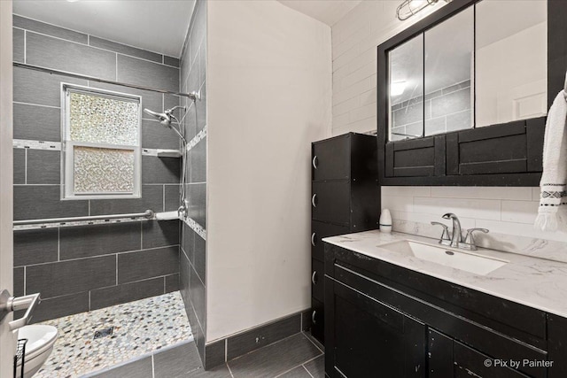 119 W S Ave, Spring Grove, IL 60081 - bathroom featuring tiled shower, vanity, toilet, and decorative backsplash