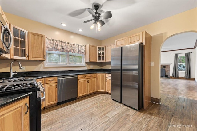 119 W S Ave, Spring Grove, IL 60081 - kitchen with appliances with stainless steel finishes, dark countertops, light wood finished floors, arched walkways, and a ceiling fan