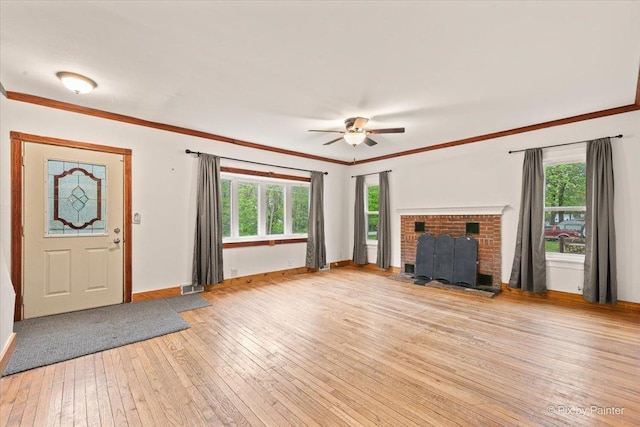 119 W S Ave, Spring Grove, IL 60081 - unfurnished living room with light wood-style flooring, baseboards, plenty of natural light, a fireplace, and ornamental molding