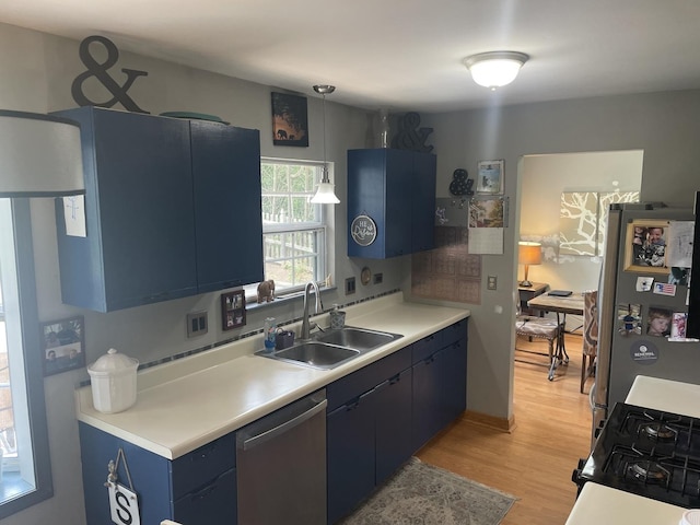30W071 Kensington Dr, Warrenville, IL 60555 - kitchen with appliances with stainless steel finishes, blue cabinets, a sink, light wood finished floors, and light countertops
