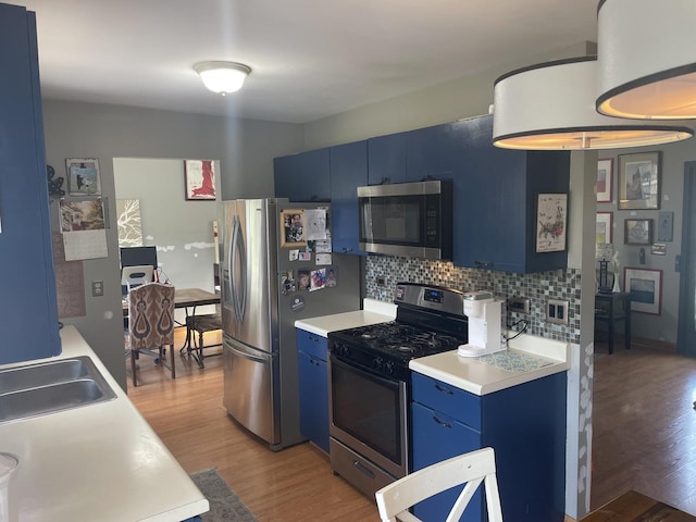 30W071 Kensington Dr, Warrenville, IL 60555 - kitchen featuring blue cabinets, appliances with stainless steel finishes, light wood-style floors, decorative backsplash, and light countertops