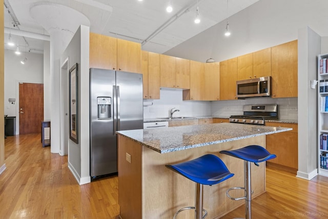 547 S Clark St Unit 704, Chicago, IL 60605 - kitchen with stainless steel appliances, a sink, light stone countertops, rail lighting, and light wood finished floors