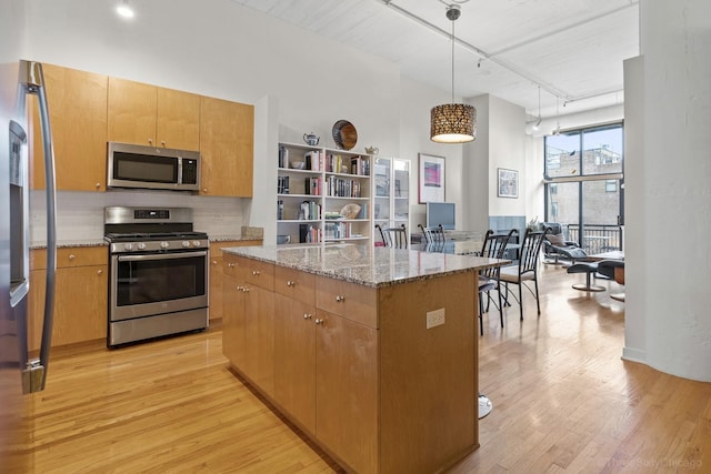 547 S Clark St Unit 704, Chicago, IL 60605 - kitchen featuring stainless steel appliances, rail lighting, light wood-type flooring, tasteful backsplash, and light stone countertops