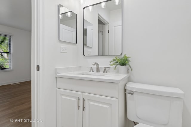 266 Mayfair Ln Unit C1, Schaumburg, IL 60193 - half bath featuring vanity, toilet, wood finished floors, and baseboards