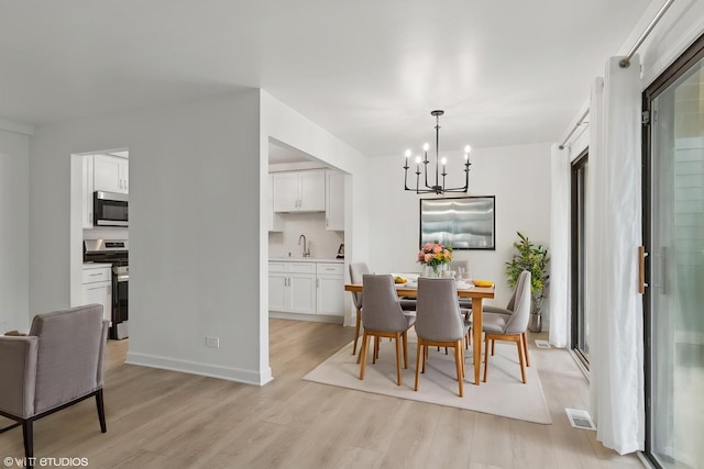 266 Mayfair Ln Unit C1, Schaumburg, IL 60193 - dining area with a chandelier, light wood-style flooring, and baseboards