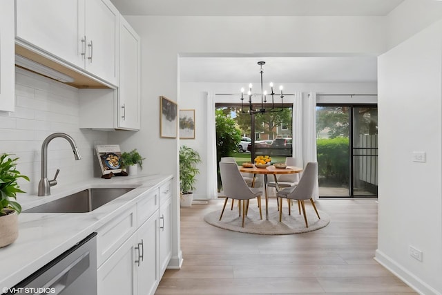 266 Mayfair Ln Unit C1, Schaumburg, IL 60193 - kitchen featuring dishwasher, a sink, a chandelier, backsplash, and white cabinetry