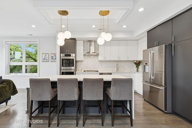 2256 W Foster Ave Unit 3, Chicago, IL 60625 - kitchen featuring appliances with stainless steel finishes, a tray ceiling, wall chimney range hood, light countertops, and recessed lighting