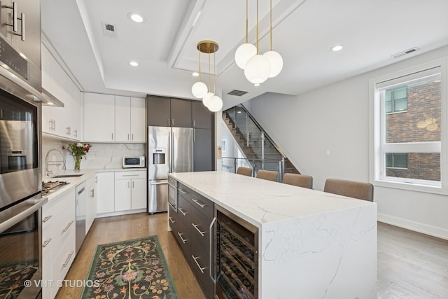 2256 W Foster Ave Unit 3, Chicago, IL 60625 - kitchen with stainless steel fridge, beverage cooler, light wood-style flooring, a center island, and recessed lighting
