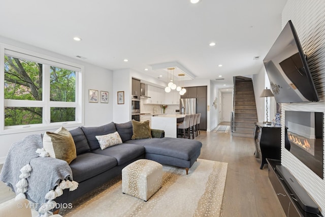 2256 W Foster Ave Unit 3, Chicago, IL 60625 - living room with light wood-type flooring, stairway, recessed lighting, baseboards, and a glass covered fireplace