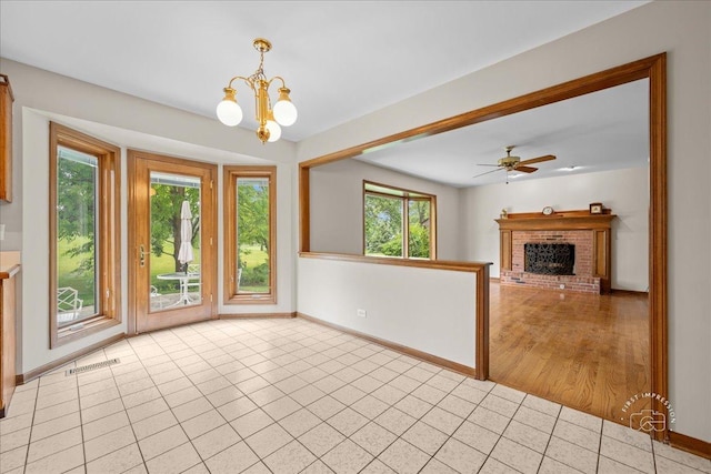 560 Braemar Ave, Naperville, IL 60563 - unfurnished dining area with a chandelier, light tile patterned floors, a brick fireplace, and ceiling fan