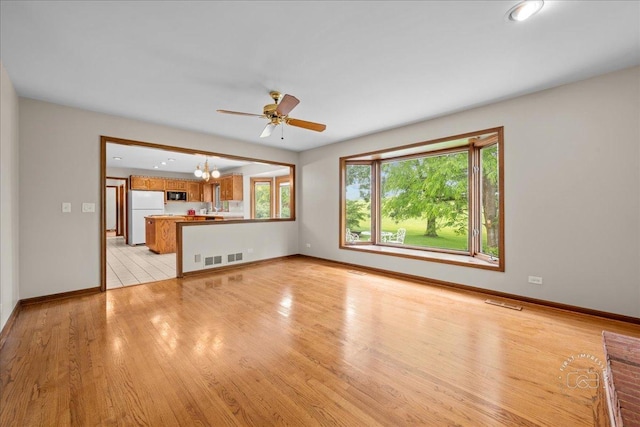 560 Braemar Ave, Naperville, IL 60563 - unfurnished living room featuring light wood finished floors, a chandelier, and ceiling fan