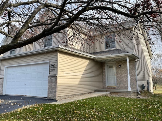 1181 Golf Ct, Dekalb, IL 60115 - view of front facade with brick siding, driveway, an attached garage, and a front lawn