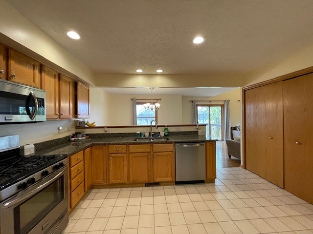 1181 Golf Ct, Dekalb, IL 60115 - kitchen featuring stainless steel appliances, a sink, a peninsula, a chandelier, and brown cabinets
