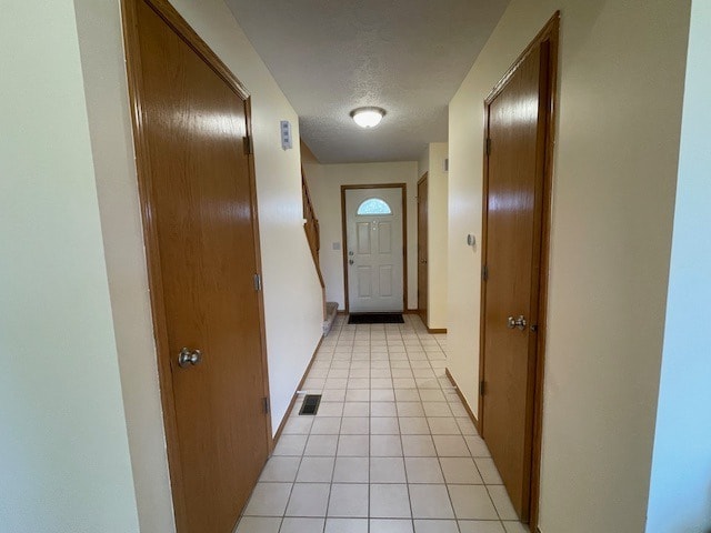 1181 Golf Ct, Dekalb, IL 60115 - hallway featuring light tile patterned flooring, a textured ceiling, and baseboards