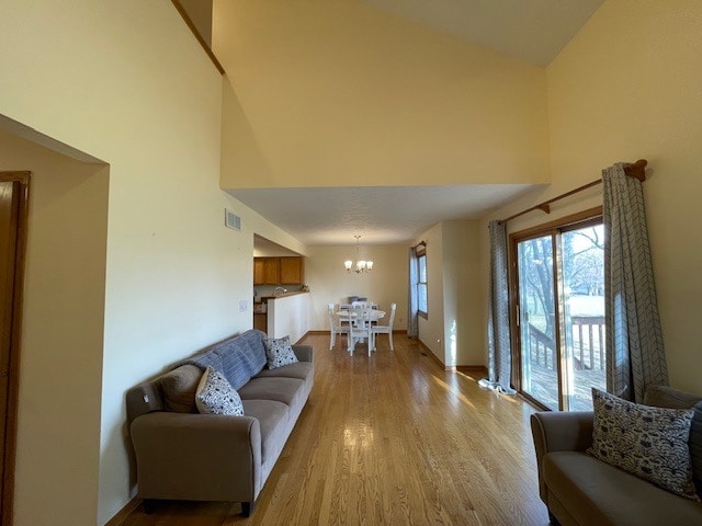 1181 Golf Ct, Dekalb, IL 60115 - living area with a towering ceiling, a chandelier, wood finished floors, and baseboards