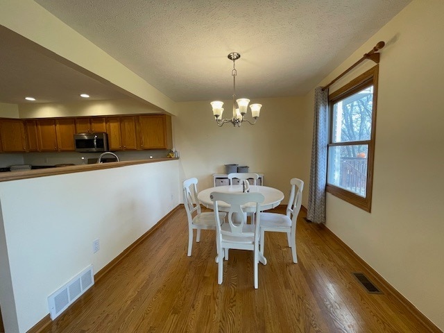1181 Golf Ct, Dekalb, IL 60115 - dining space with a chandelier, wood finished floors, a textured ceiling, baseboards, and recessed lighting